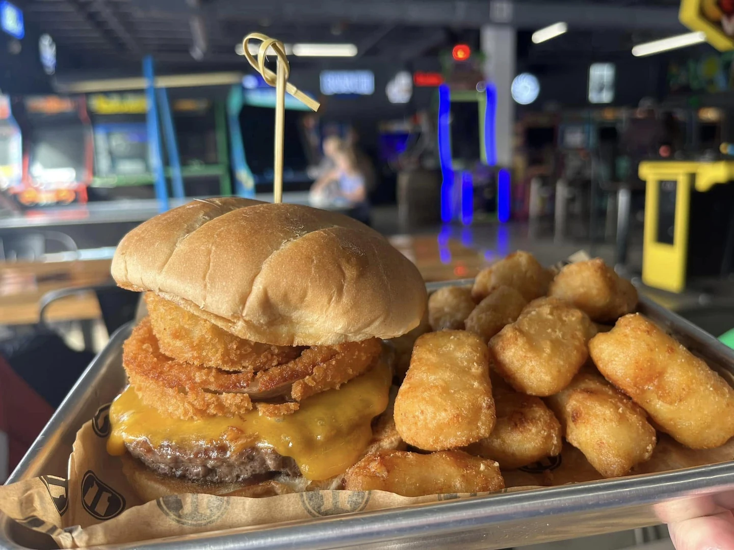 Cheeseburger with onion rings and golden fried sides at Arcade 11